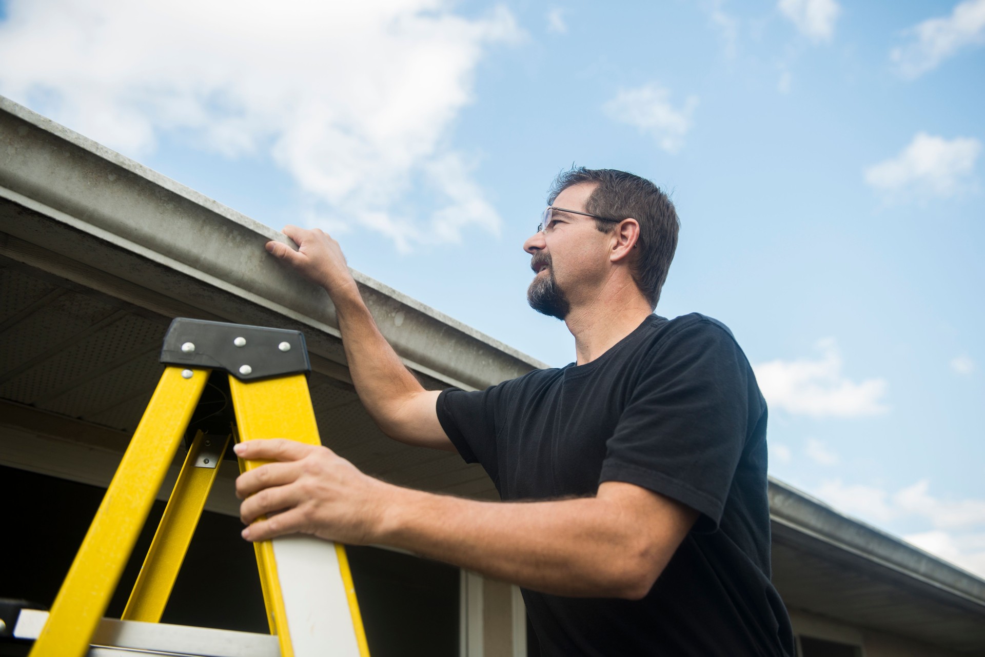 American Man Inspects Roof Condition of House for Insurance